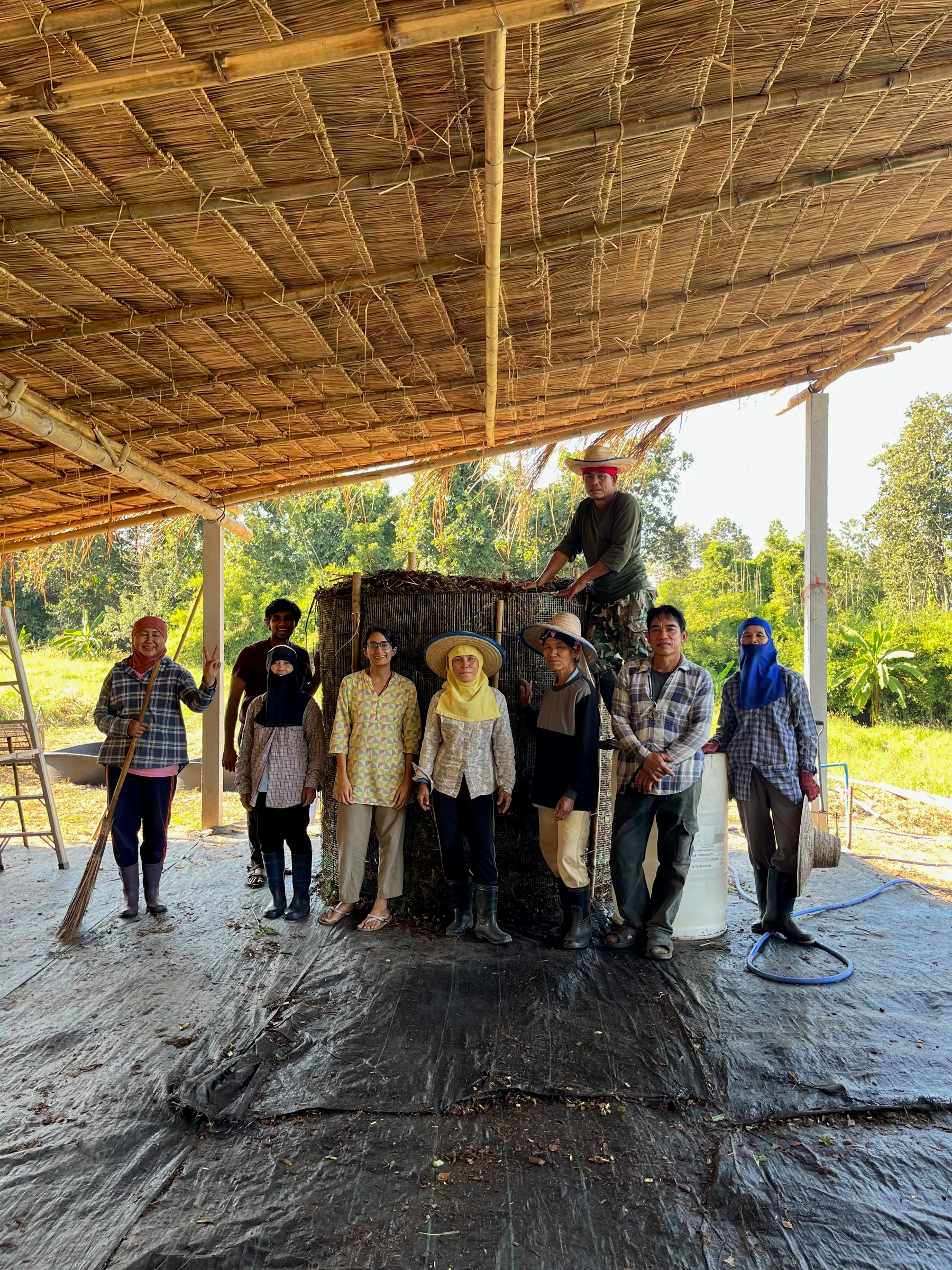 Our farm team together under the thatched roof